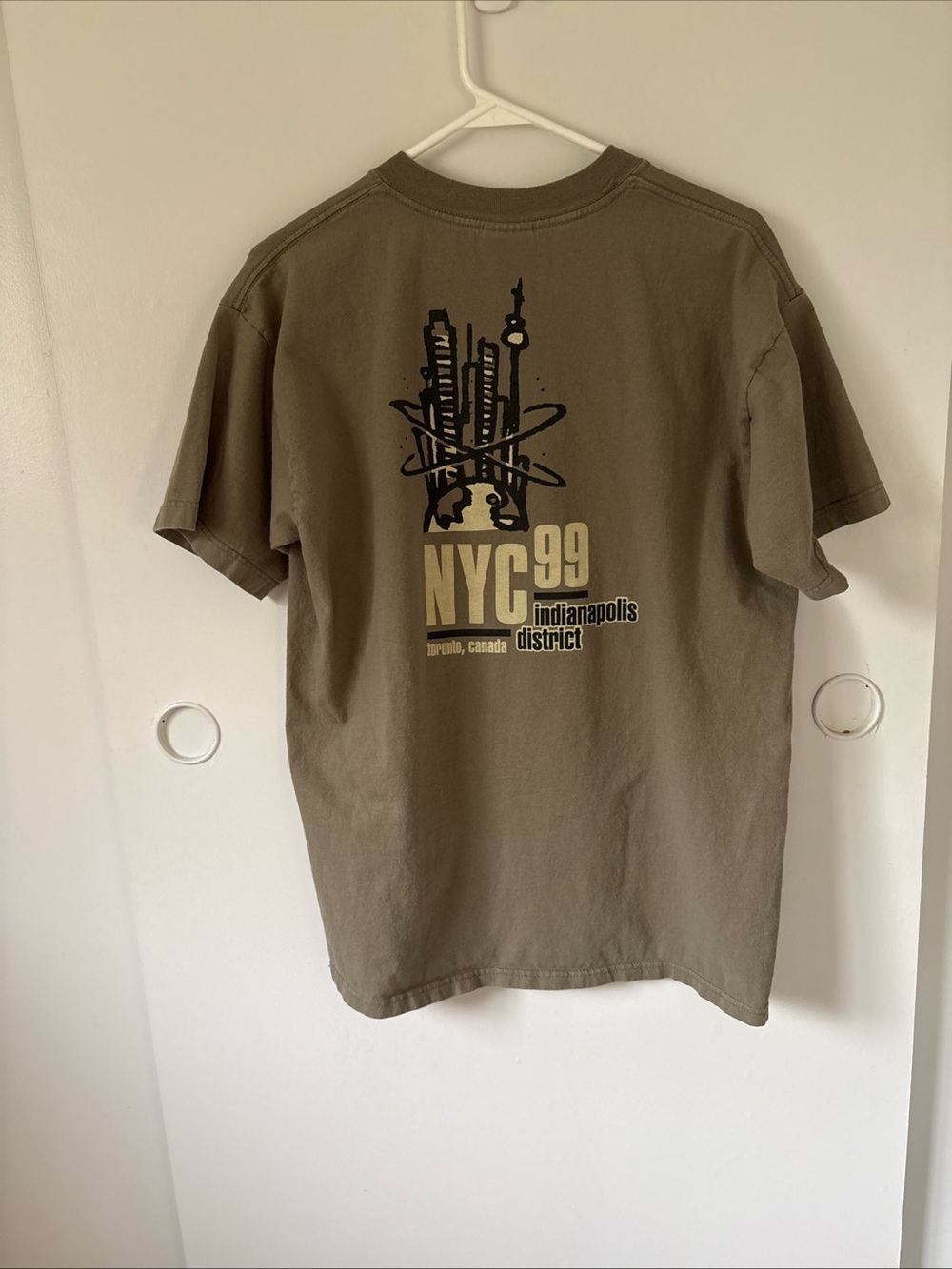 Men’s vintage olive green graphic t-shirt featuring a "NYC 99" design